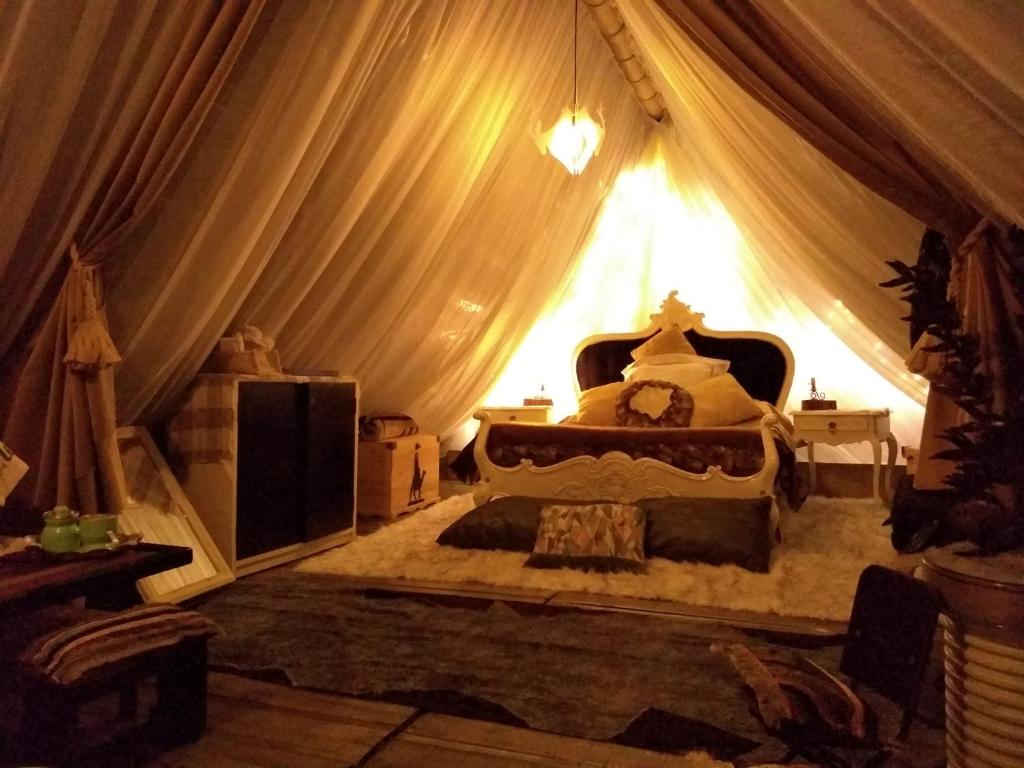 ein Schlafzimmer mit einem Bett in einem Zelt in der Unterkunft Glamping Tierra Dulce in Supatá