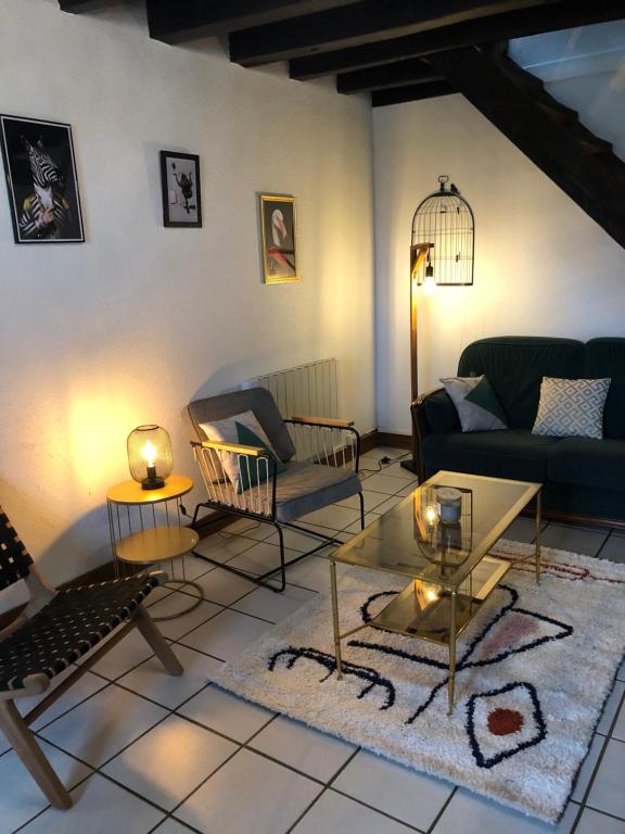 ein Wohnzimmer mit einem Sofa und einem Tisch in der Unterkunft Gîte à la ferme chaleureux avec cheminée in Préveranges