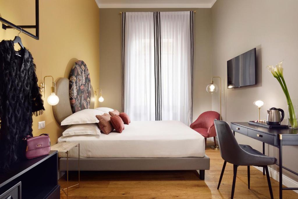 a bedroom with a bed and a desk and a chair at Dimora ai Fori - Guest House in Rome