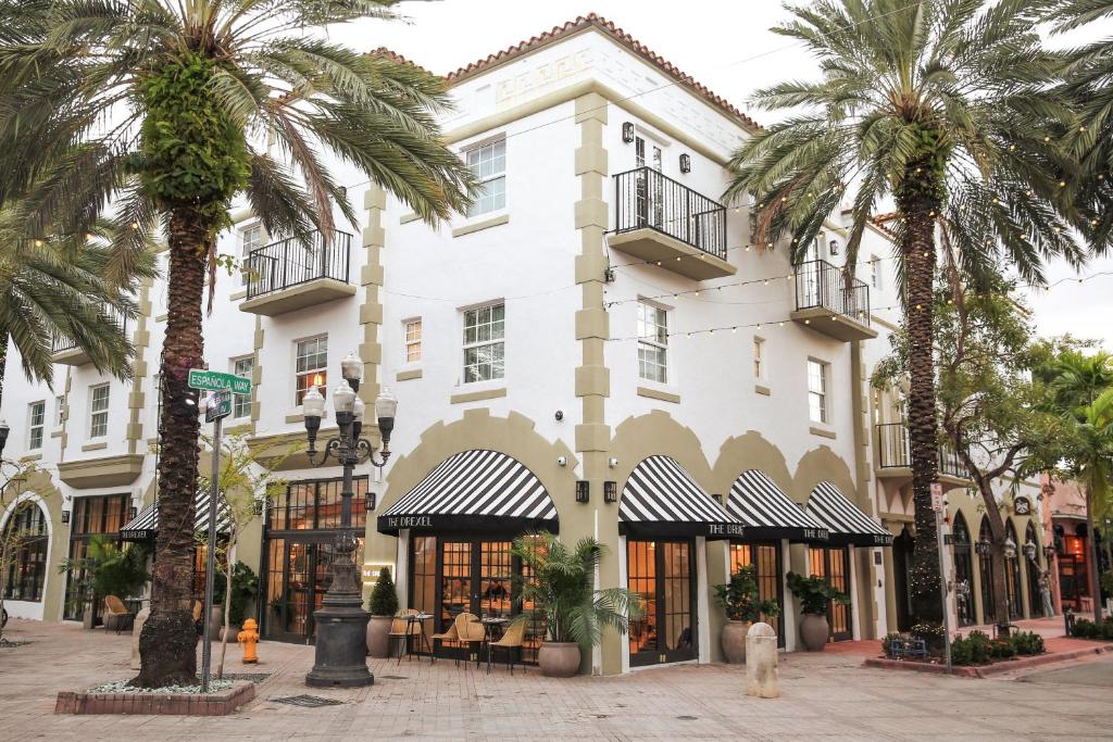 a white building with palm trees in front of it at Esme Miami Beach in Miami Beach