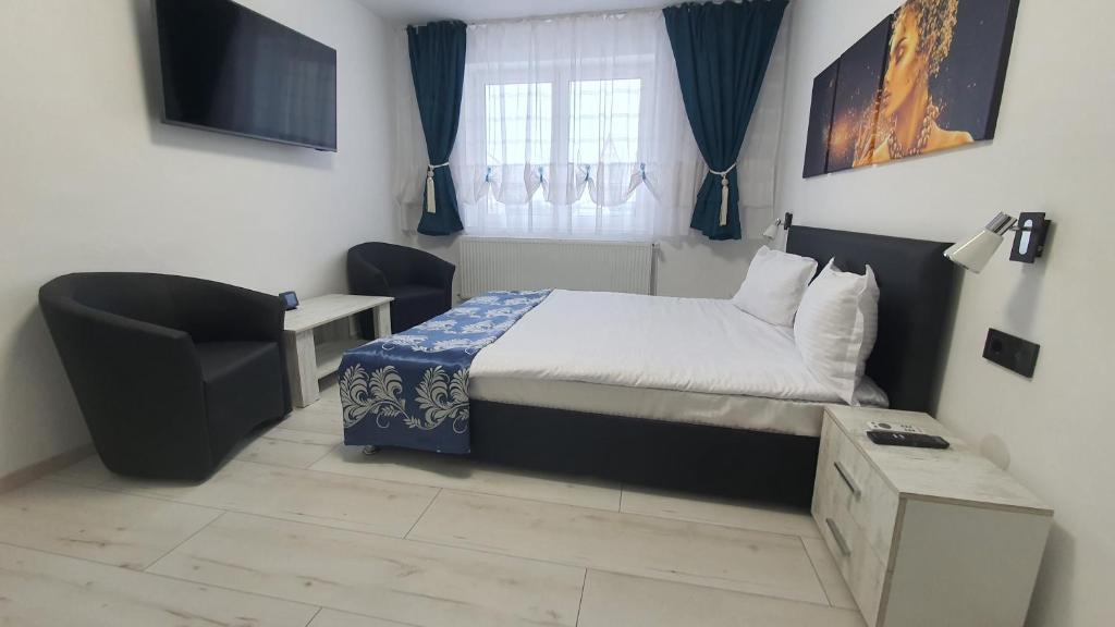 una piccola camera con letto e sedia di Apartament Fodor a Topliţa