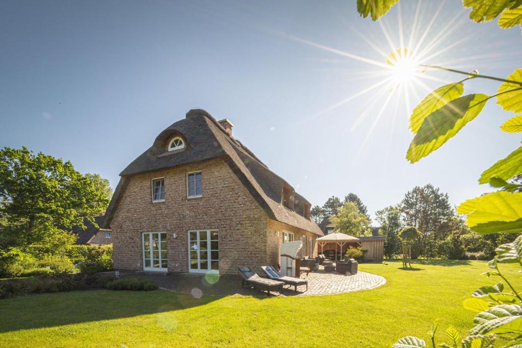 ein großes Backsteinhaus mit einem Dach auf einem Rasen in der Unterkunft Ferienhaus Koellers Hus in Sankt Peter-Ording