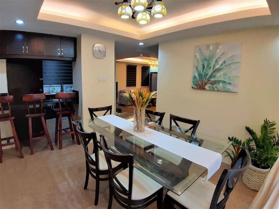 a dining room with a glass table and chairs at La Casa Felice in Angeles