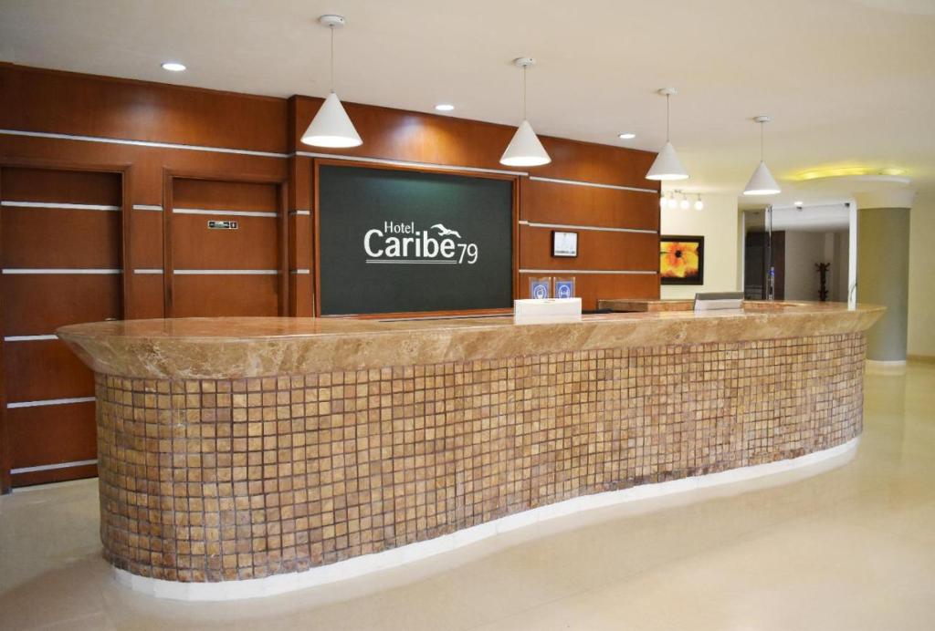 a hotel lobby with a counter with a sign on it at Hotel Caribe 79 in Barranquilla