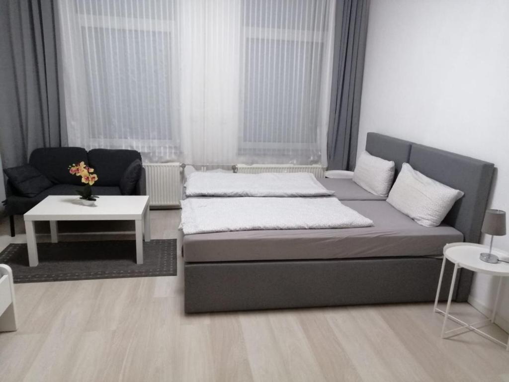 Wohnung in Köln 2B في كولونيا: غرفة نوم بسرير واريكة وطاولة