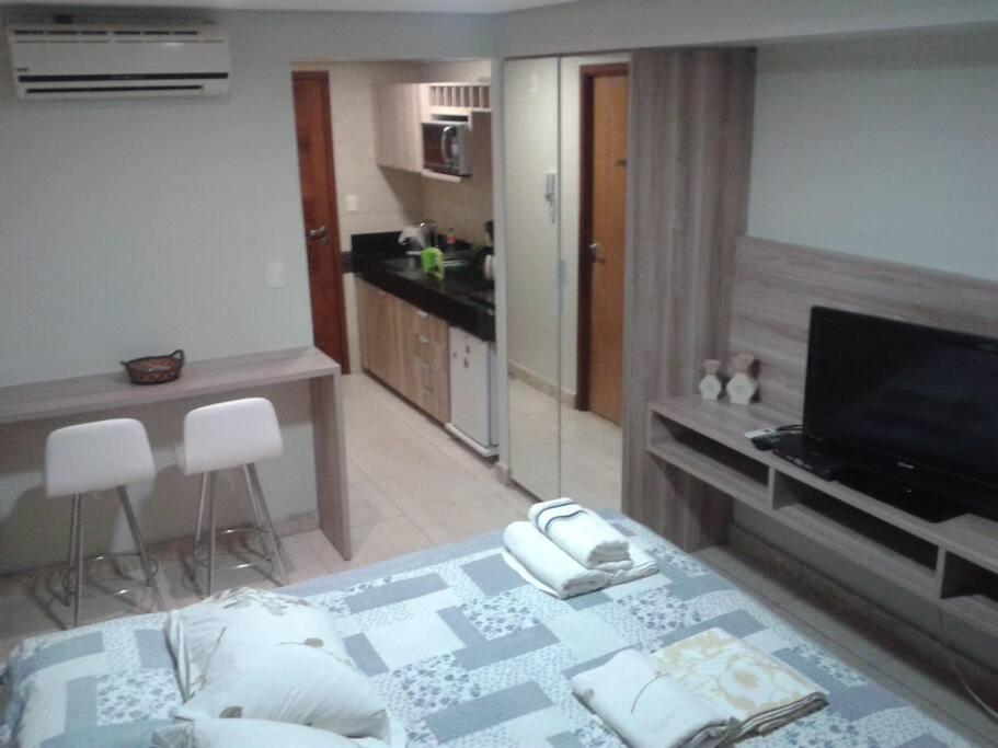 un salon avec un lit et une télévision dans l'établissement Flat Praia do Cabo Branco - Casados para sempre!, à João Pessoa