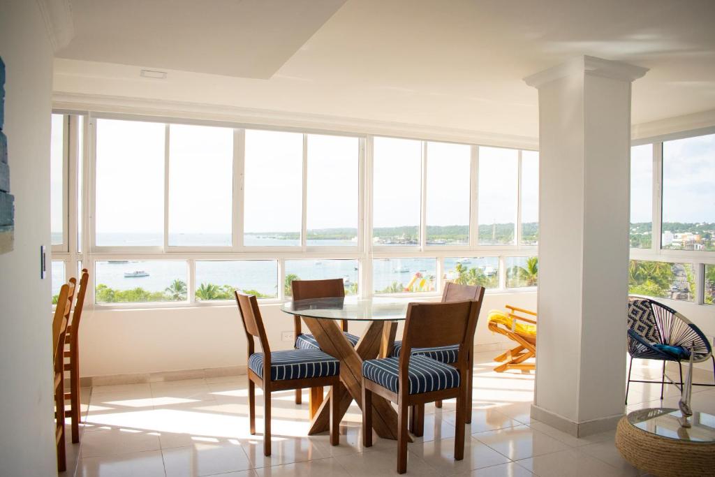 a dining room with a table and chairs and windows at Bahia Maria in San Andrés