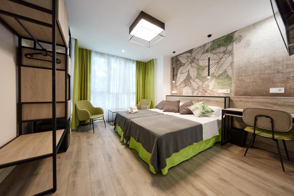 a bedroom with a bed and a desk and chairs at Wayteko Boutique Hotel in Alicante