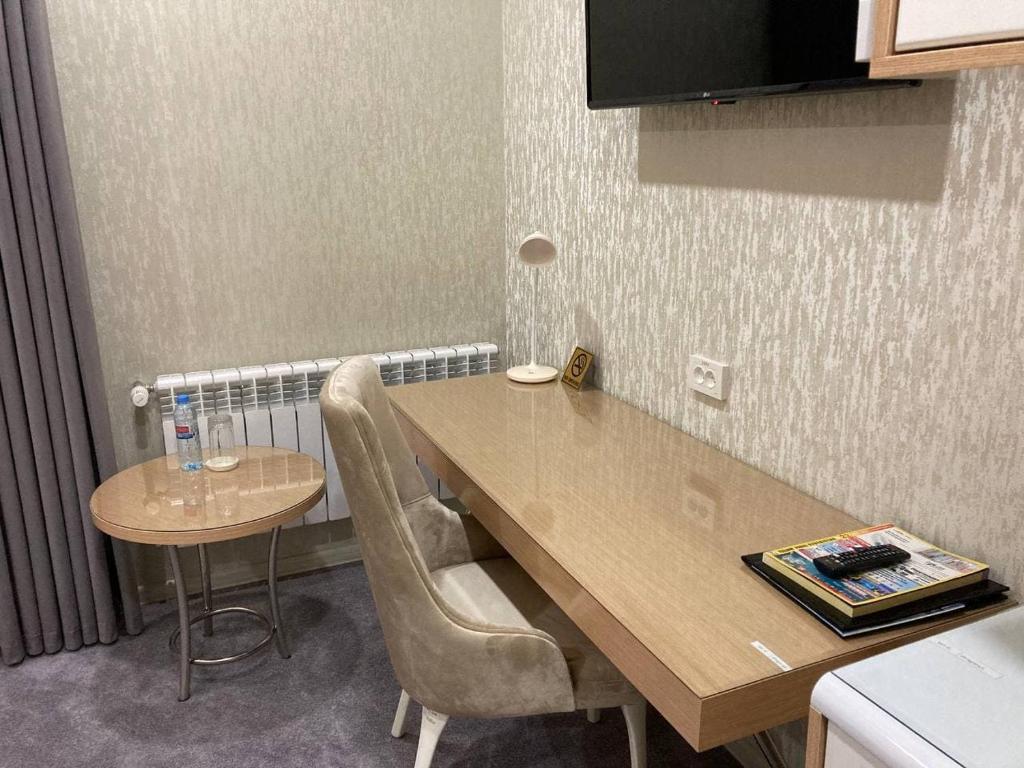 a kitchen with a wooden table and chairs at Reikartz Amirun Tashkent in Tashkent