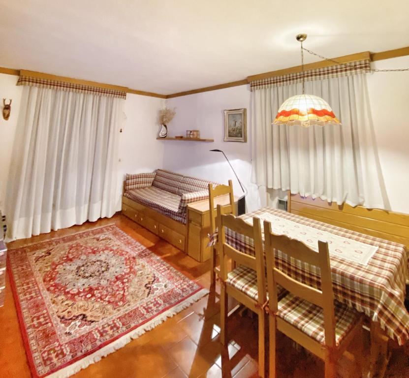 um quarto com 2 camas, uma mesa e cadeiras em Trilocale accogliente con camino a pochi minuti da Madonna di Campiglio em Spiazzo