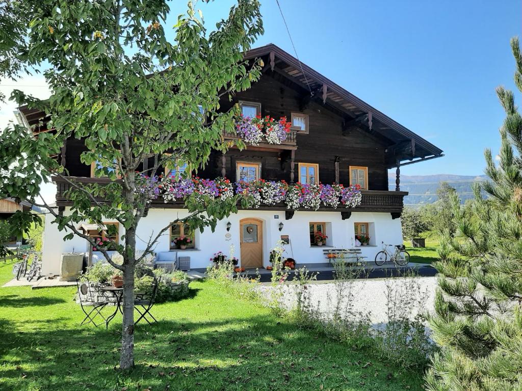 a house with flowers in front of it at Appartement Huebgut in Bruck an der Großglocknerstraße