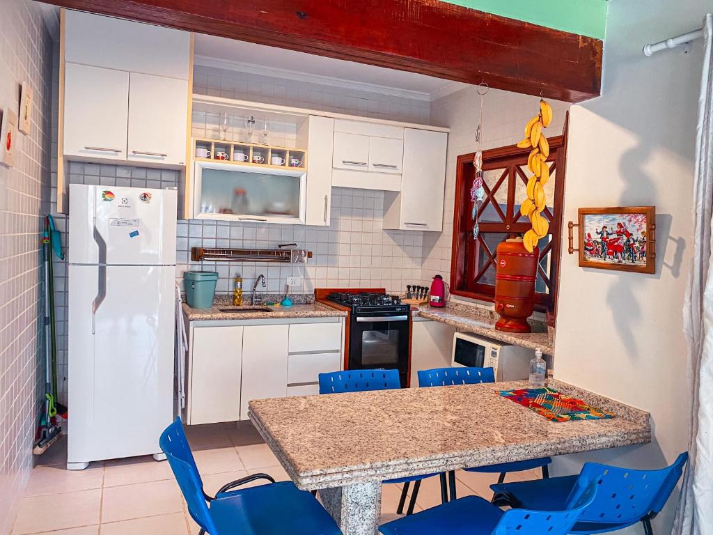 a kitchen with a refrigerator and a table and chairs at Flat 1 Dorm. Maresias Praia&Lazer& Ar&Piscina F3 in São Sebastião