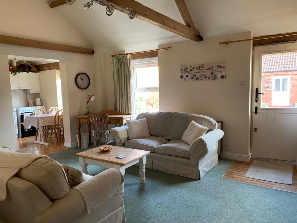 a living room with two couches and a table at Bramble cottage at Waingrove Farm in Louth