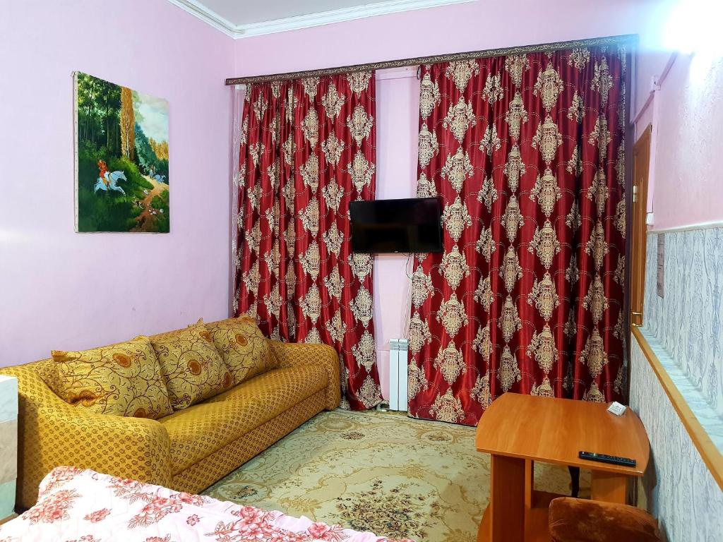 キスロヴォツクにあるУл. Володарского 4のリビングルーム(黄色のソファ、赤いカーテン付)