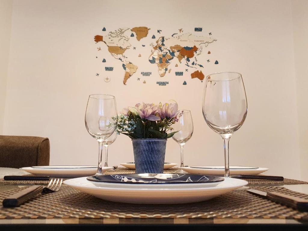 a table with two wine glasses and a world map on the wall at ARTment! A new and stylish apartment for you - Free parking in Braşov