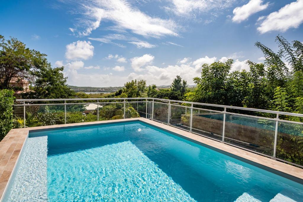 a swimming pool on the balcony of a house at Villa Saint Corentin - 4 étoiles - Cap Est in Le François