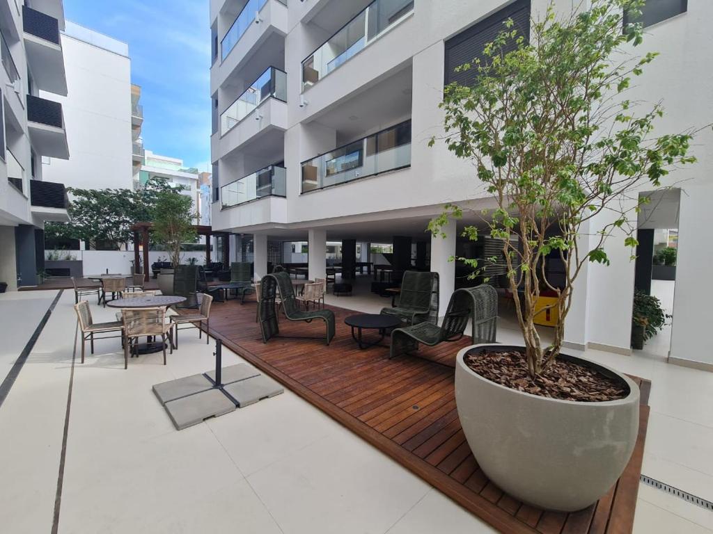 a wooden deck with a tree on a building at Apartamento 2 quartos home club na praia de palmas in Governador Celso Ramos