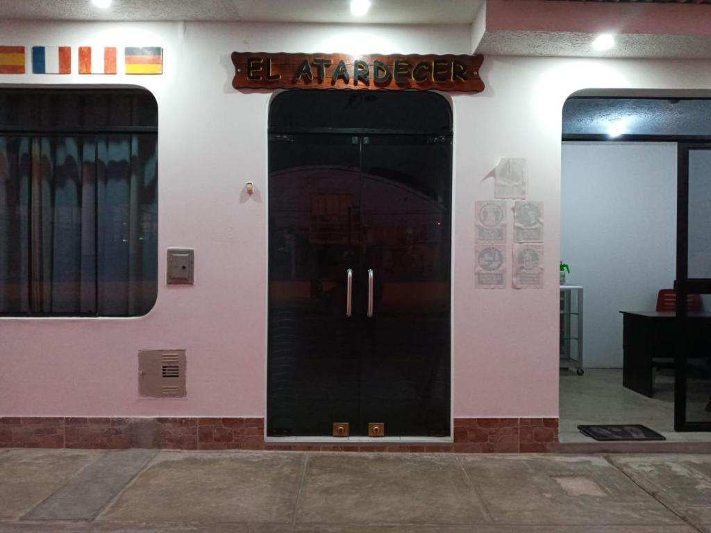 eine Tür zu einem Gebäude mit einem Schild darauf in der Unterkunft El Atardecer in Paracas