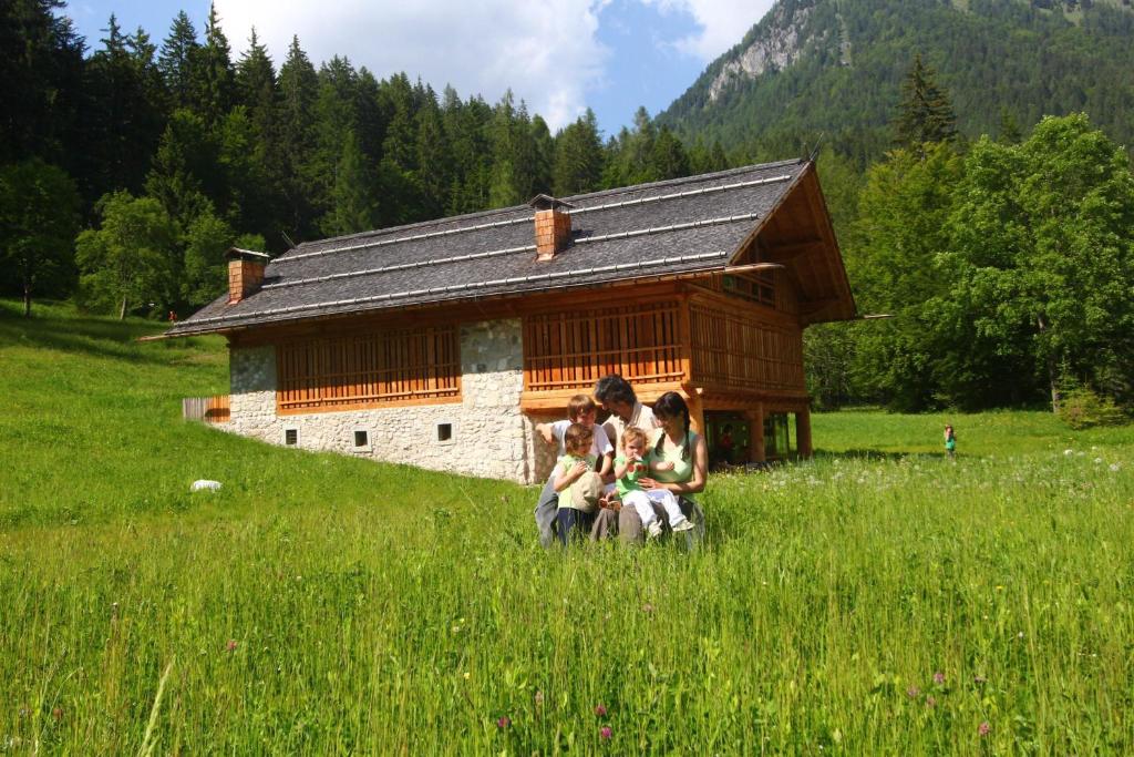 um grupo de pessoas em um campo em frente a um edifício em Pra de la Casa em Madonna di Campiglio