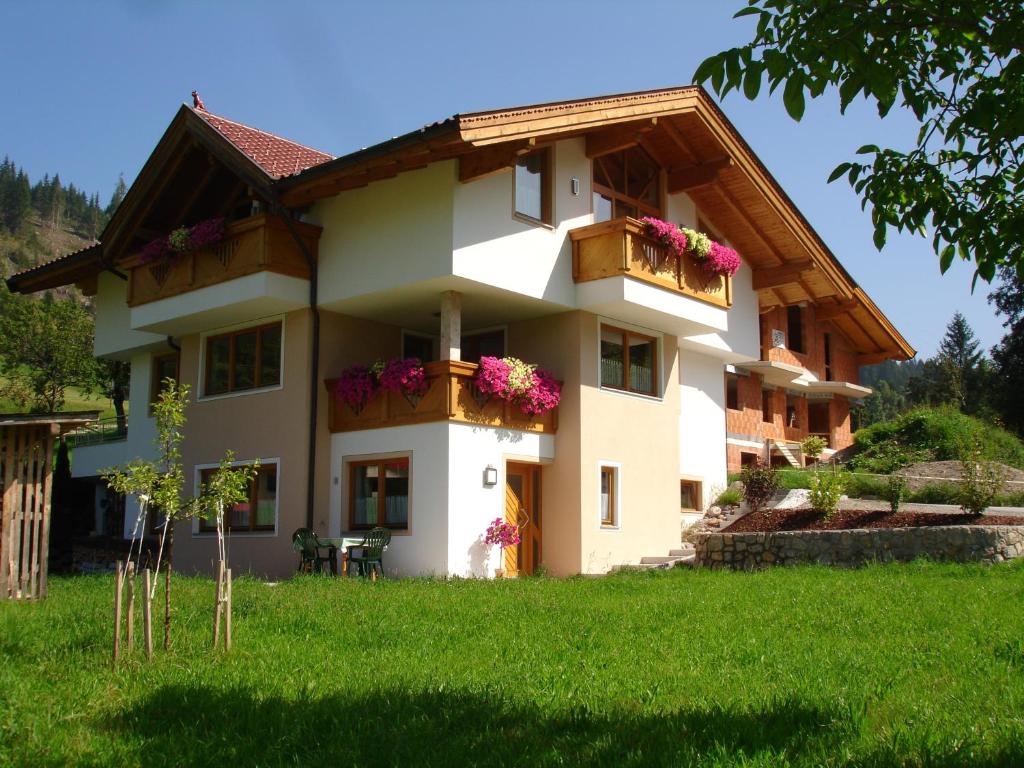 ein Haus mit Blumen auf den Balkonen darauf in der Unterkunft Haus Gföller in Niederau