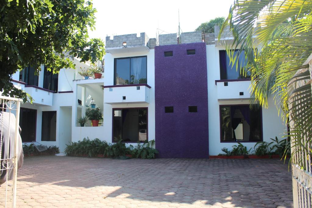 un bâtiment avec un mur violet et une cour dans l'établissement Hotel Palmarito, à Puerto Escondido