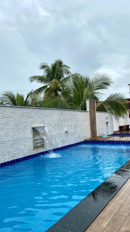 a swimming pool with a water fountain in a building at Pousada Manancial in Itaúnas