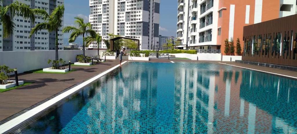 a large swimming pool in a city with buildings at Meritus Apartment in Perai