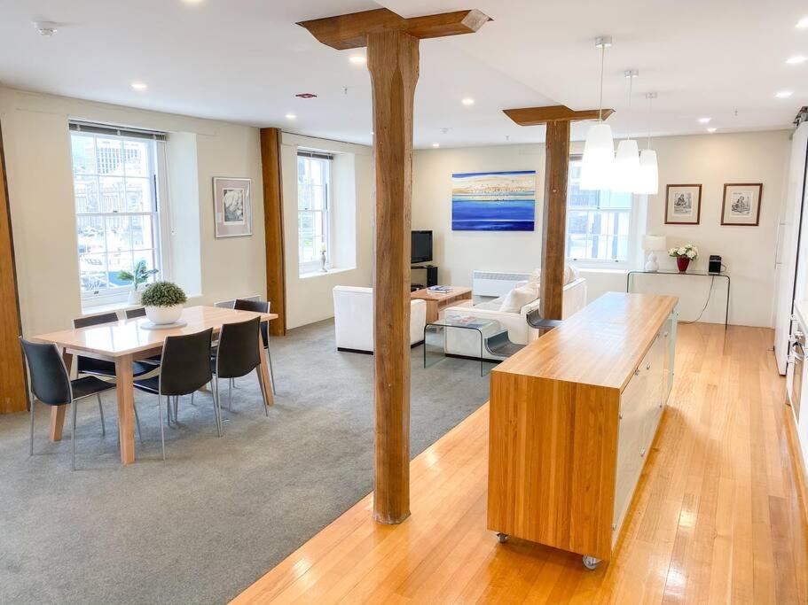 a living room with a table and a dining room at Luxury Hobart Waterfront Apartment with views! in Hobart