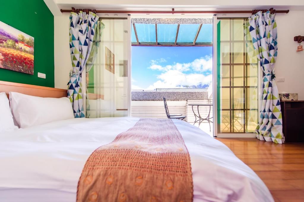 een slaapkamer met een bed en uitzicht op de oceaan bij Ying Hsuan House in Hualien