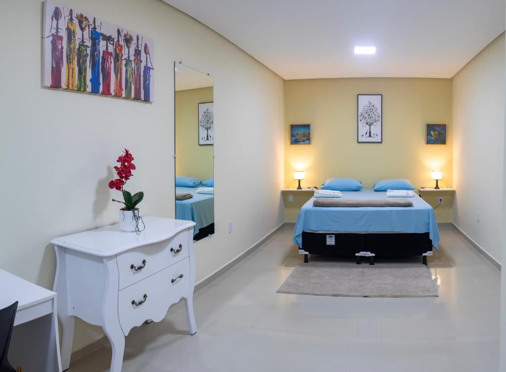 een slaapkamer met 2 bedden en een spiegel bij Lençóis Prime Apartments in Lençóis
