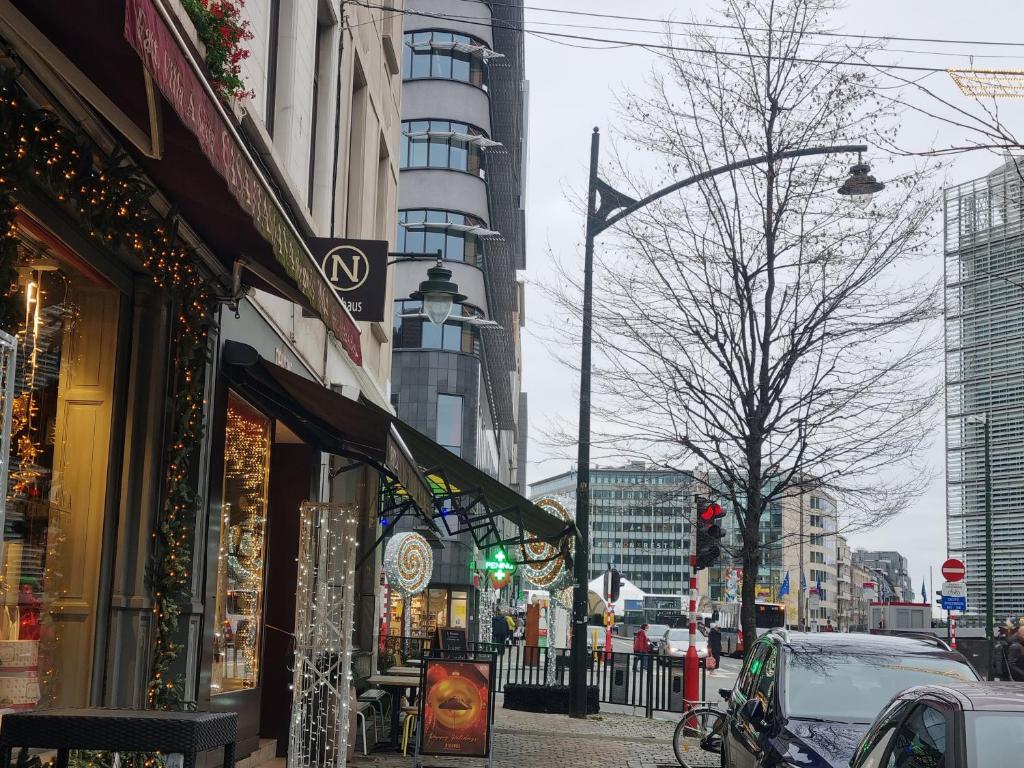 eine belebte Stadtstraße mit Gebäuden und grüner Ampel in der Unterkunft Apartments Berlaymont OHY in Brüssel