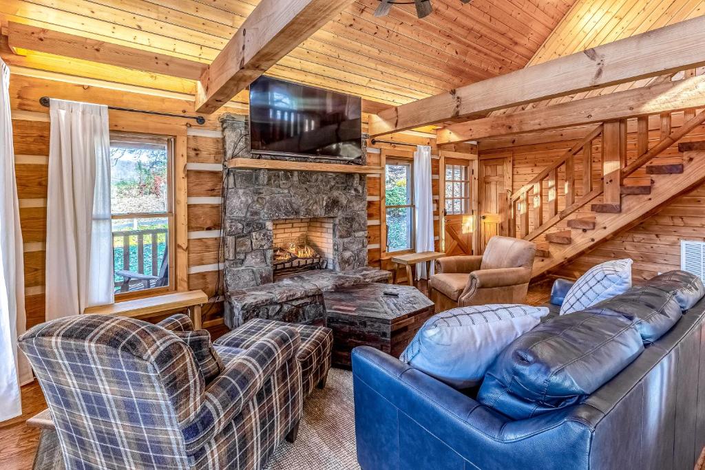 a living room with couches and a fireplace in a log cabin at The Meadows at Country Acres in Whittier