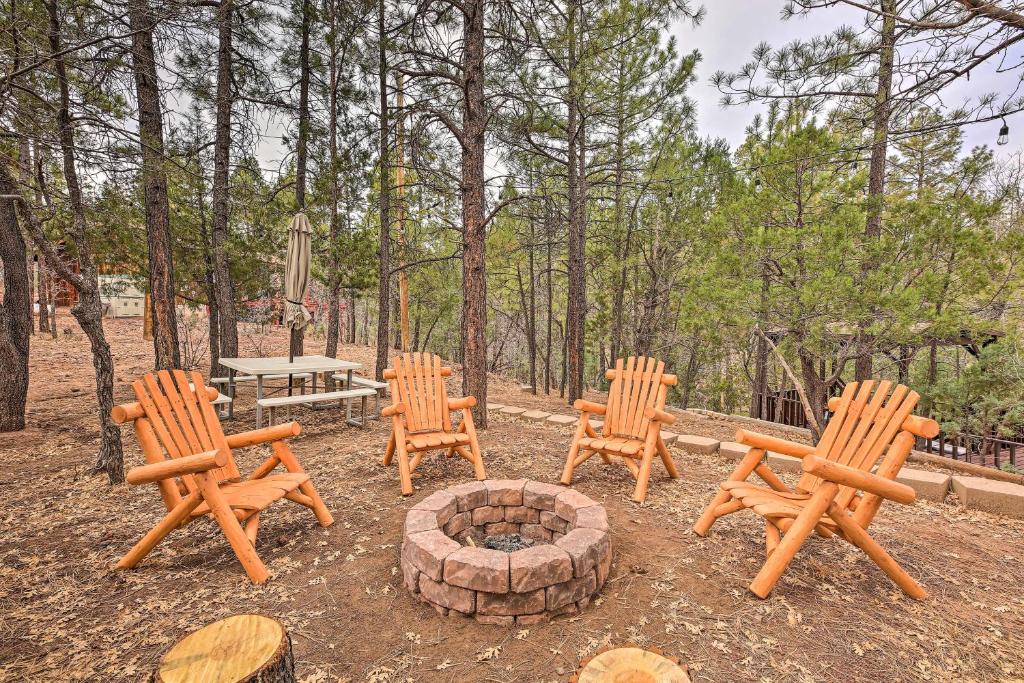 a group of wooden chairs and a fire pit at Show Low Cabin with BBQ and Fire Pit Pets Welcome! in Show Low