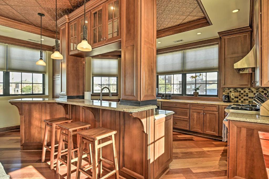 Una cocina con muebles de madera y una barra con taburetes. en Spacious Indianapolis Condo with Private Gym!, en Indianápolis