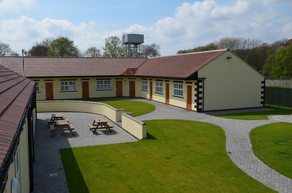 een gebouw met een patio met een tafel en banken bij The Reindeer Inn in Sandtoft