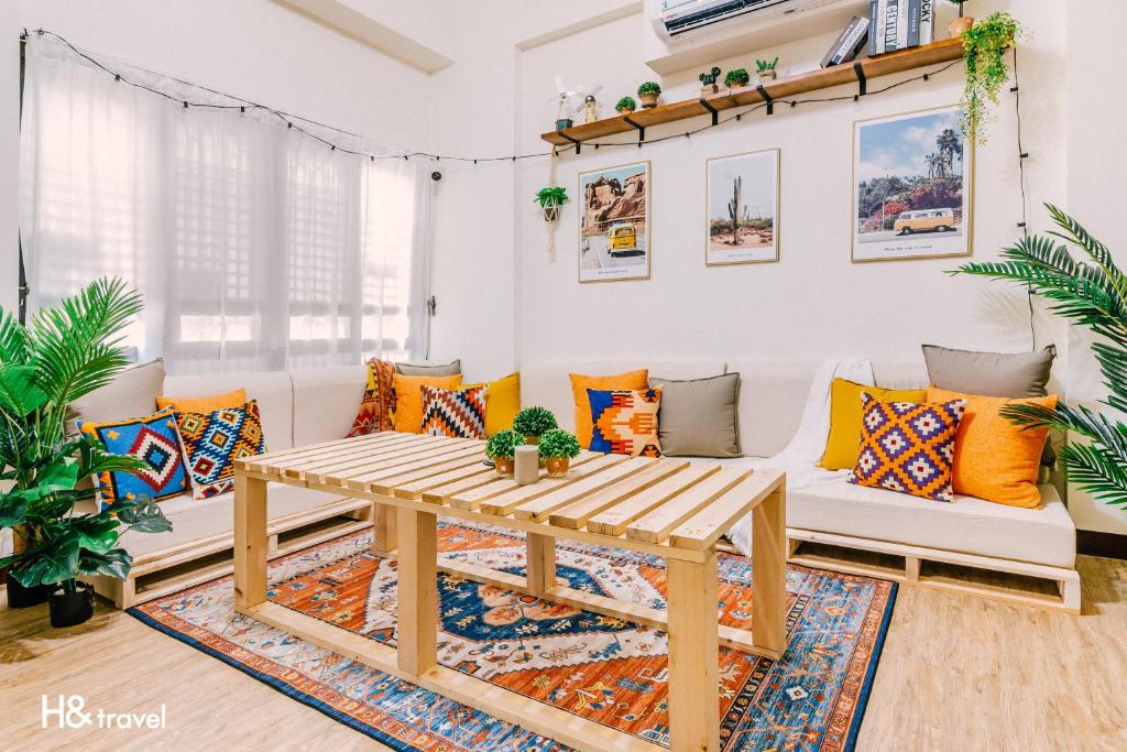 台南的住宿－海安藝術公寓民宿，客厅配有白色的沙发和木桌