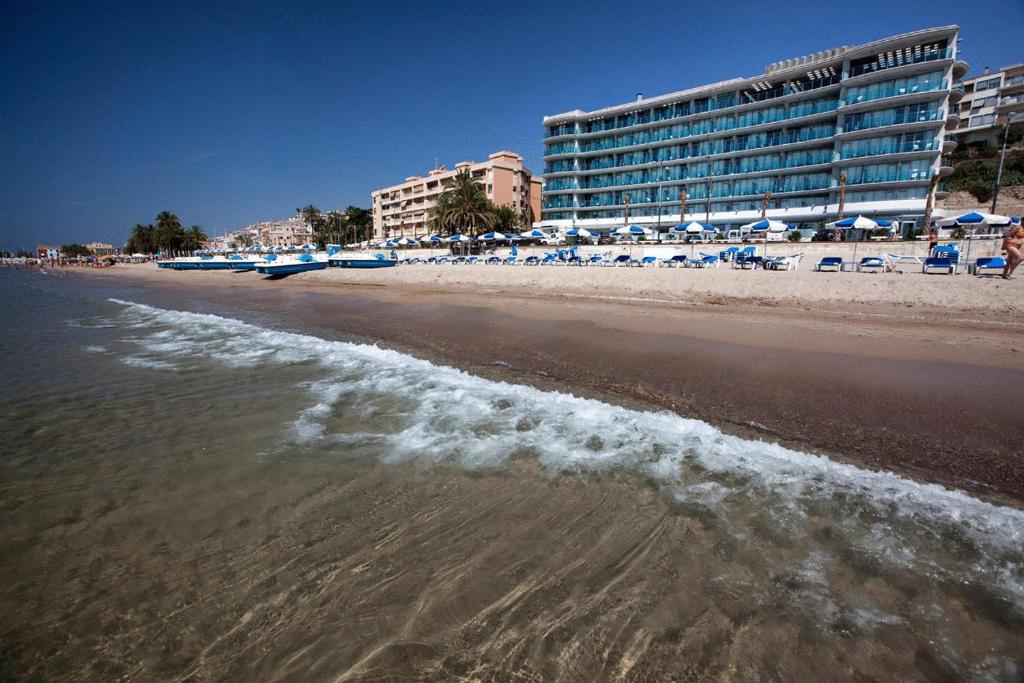 ビリャホヨサにあるHotel Allon Mediterraniaのホテルを背景にビーチの景色を望めます。