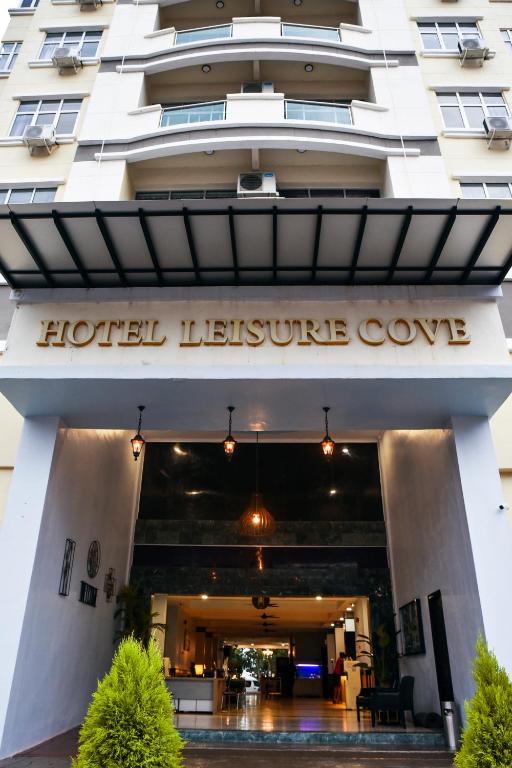 a hotel entrance with a hotel leisure cove sign on it at Leisure Cove Hotel and Apartments in George Town