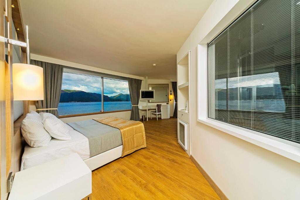 een slaapkamer met een bed en een groot raam bij Poseidon Hotel - Adult Only in Marmaris