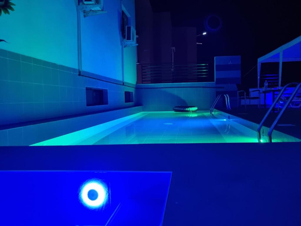 a swimming pool with blue lights in a room at Résidence Blue hôtel in Thiès
