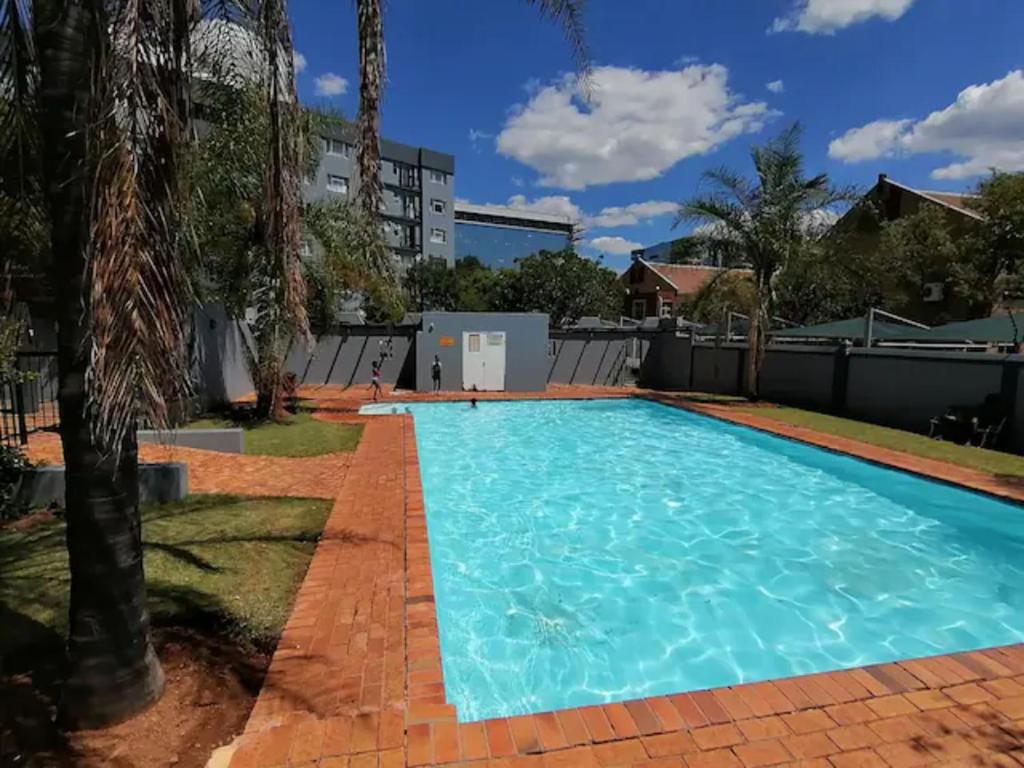 una grande piscina con acqua blu in un cortile di Menlyn Maine Apartments, Menlyn Place a Pretoria
