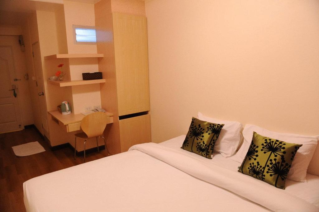 Kleines Zimmer mit 2 Betten und einem Schreibtisch. in der Unterkunft The Blooms Residence in Bangkok