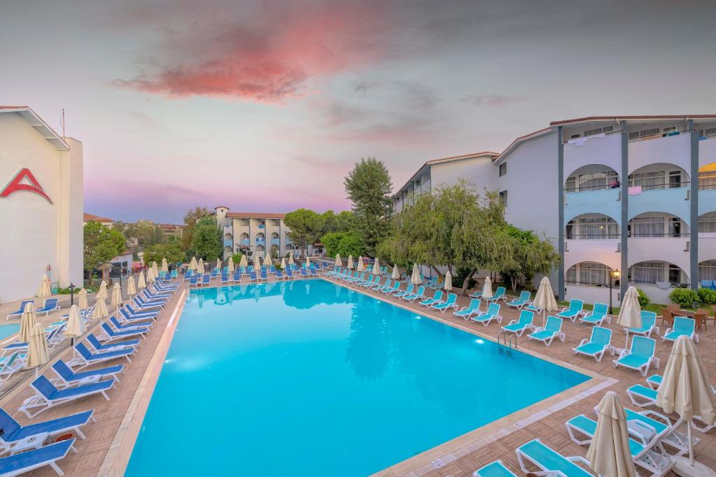 a pool with lounge chairs and umbrellas at a hotel at Armas Bella Sun in Side