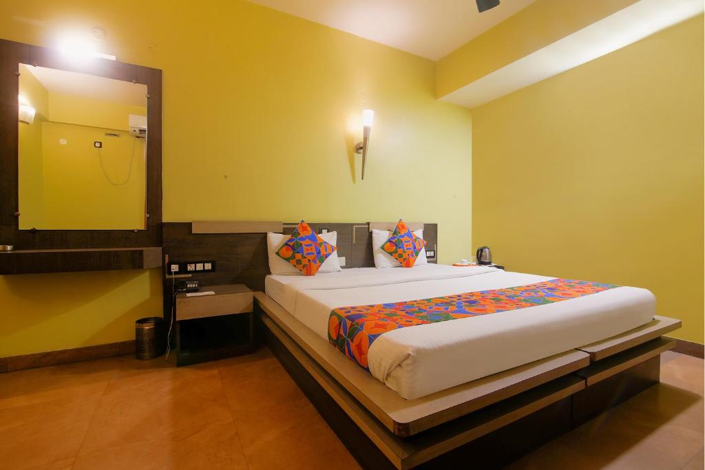 a bedroom with a large bed with a large mirror at FabHotel Elements Inn in Patna