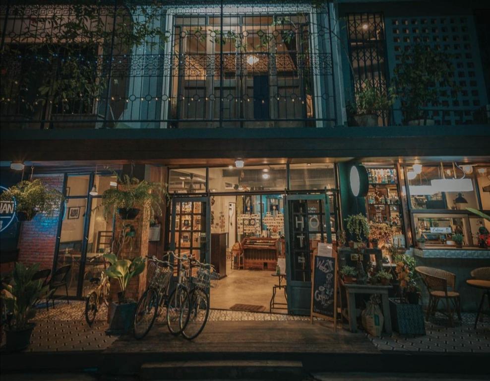 Chernchan Hostel في تشانتابوري: متجر به دراجات متوقفة خارجه في الليل