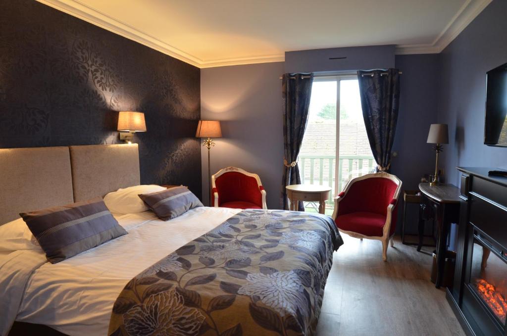 a hotel room with a bed and chairs and a window at Villa Augeval Hôtel de charme & Spa in Deauville