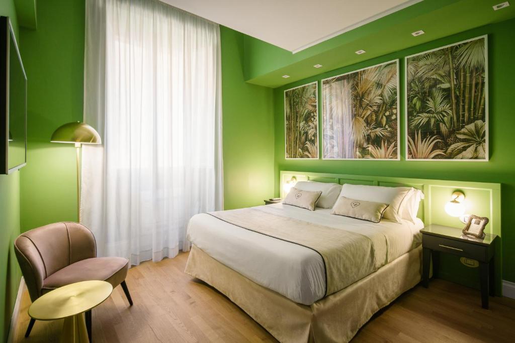 1 dormitorio verde con 1 cama y 1 silla en Birkin Porto 1870 en Cagliari