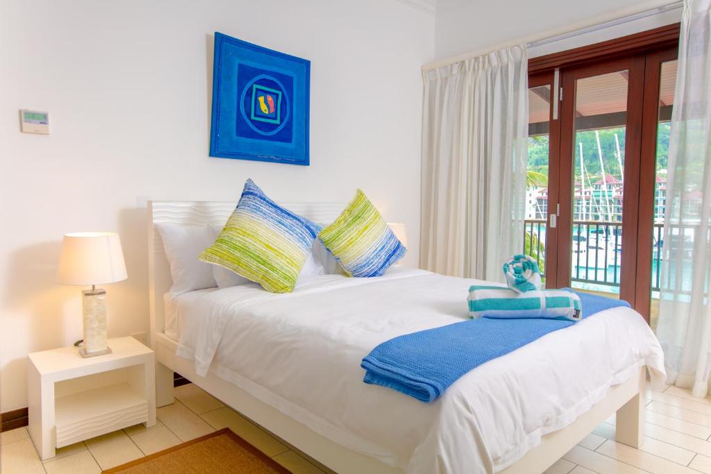 a bedroom with a white bed and a window at Eden Studios in Mahe