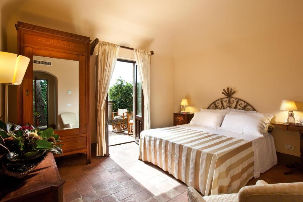 1 dormitorio con 1 cama y puerta que da a un patio en Casa la Carrubbazza en San Gregorio di Catania