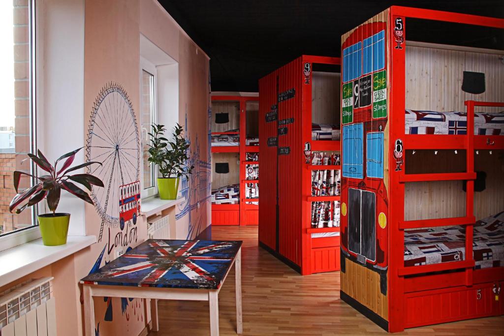 a room with red shelves and a table and a chair at Хостел Жить просто 2 in Pyatigorsk